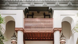 Een binnenplaats met een zwembad, een zithoek met een tafel en een balkon.