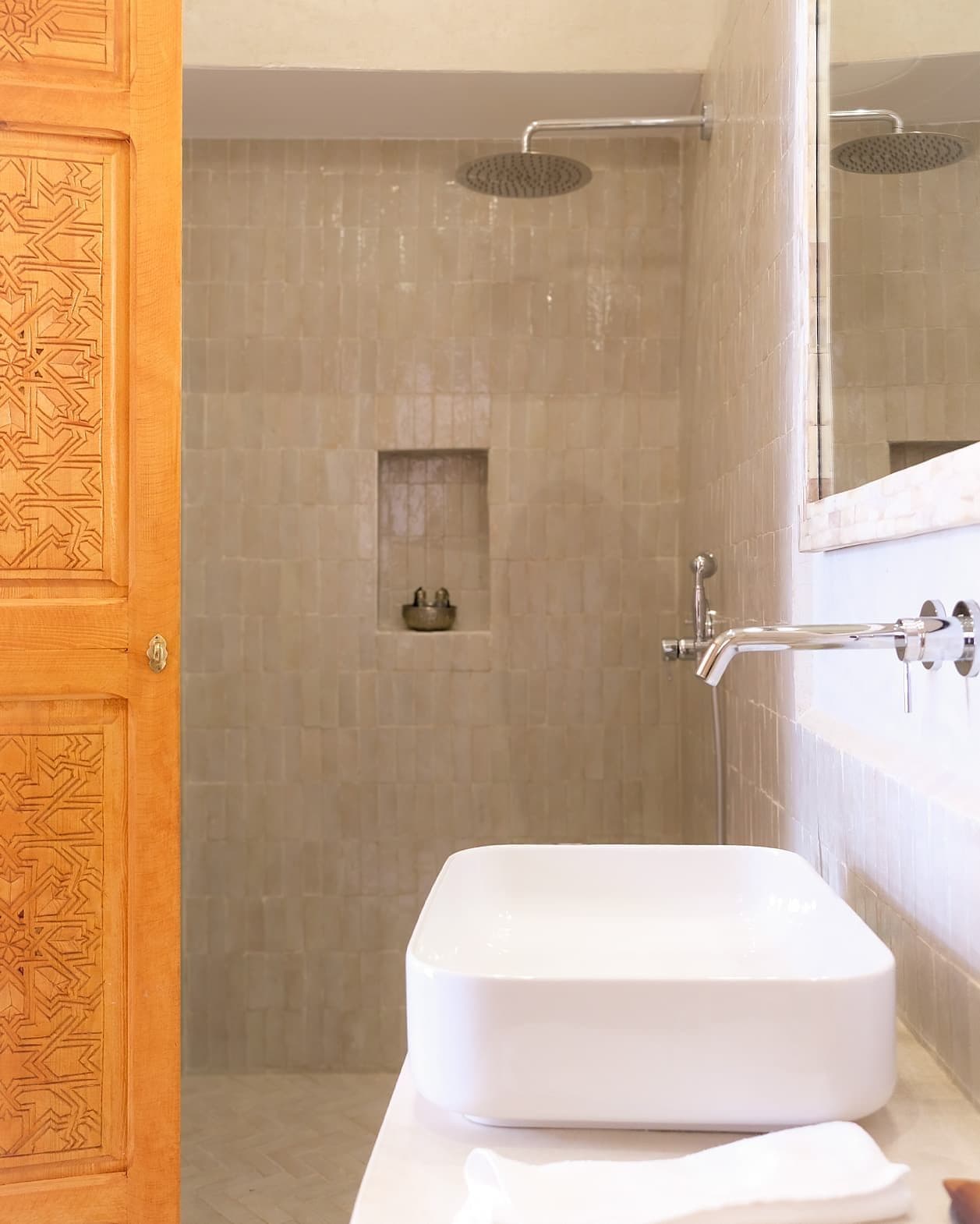 A bathroom with a shower, a sink, and a mirror.