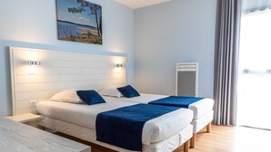 A double bed with a headboard, two bedside tables, a nightstand, a window with curtains, and a wall-mounted air conditioning unit.