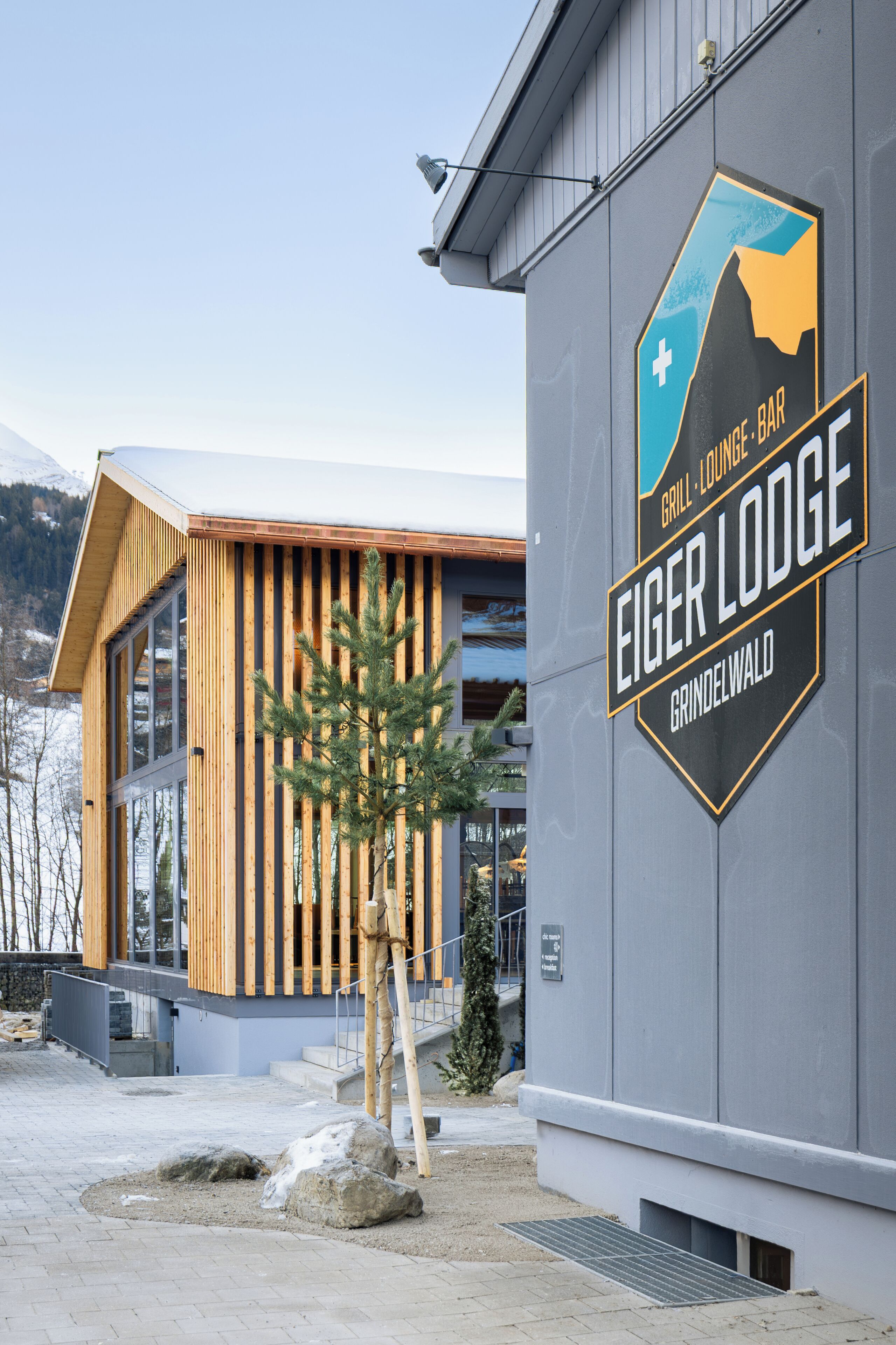 Un edificio con un letrero que dice 'Eiger Lodge Grindelwald', indicando un restaurante y bar.