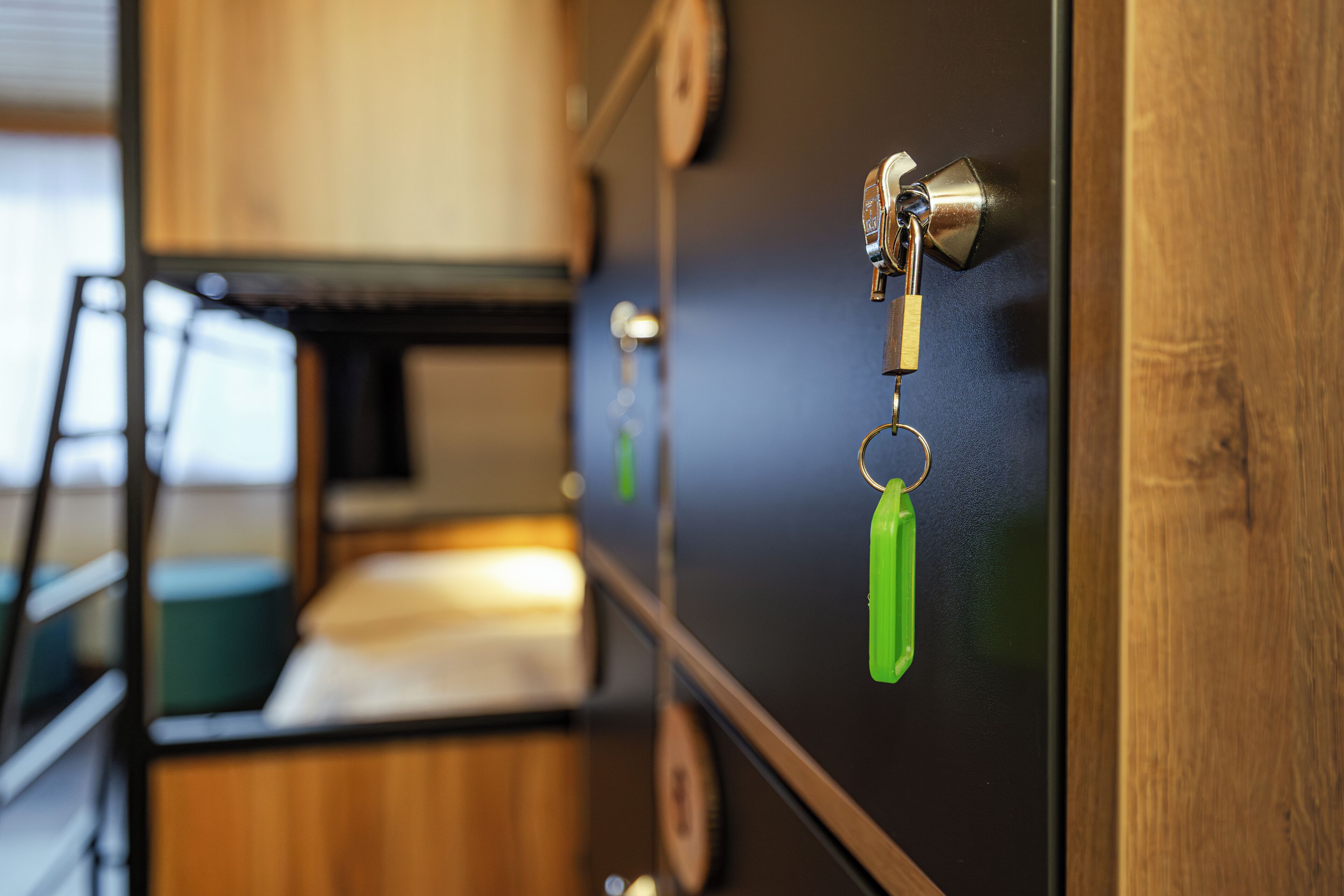 A close-up of a door with a keyhole, a padlock, and a green keychain.