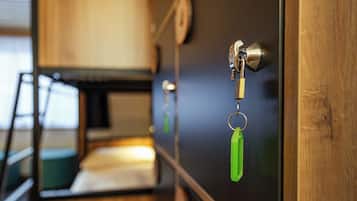 A close-up of a door with a keyhole, a padlock, and a green keychain.