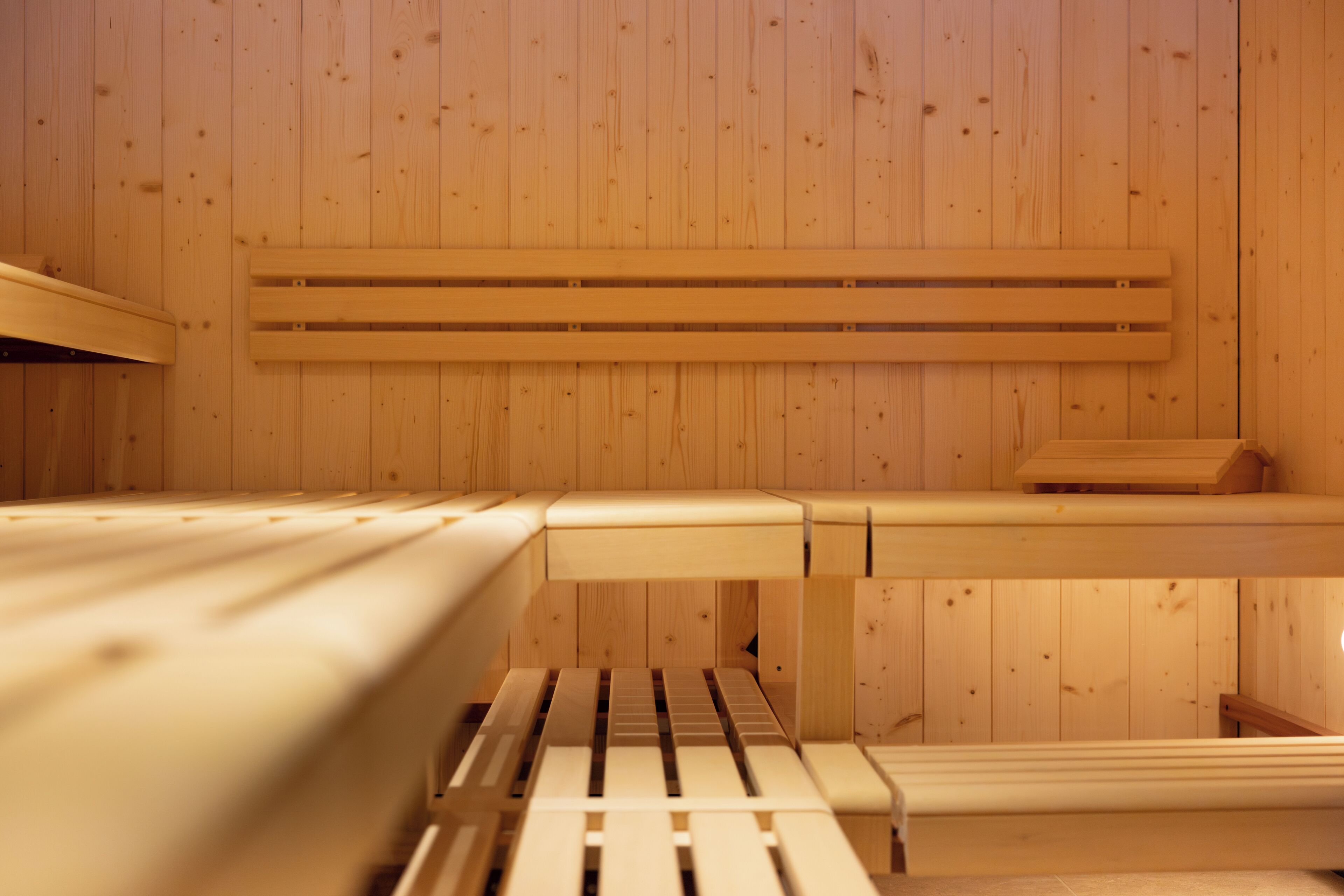 Un sauna avec des murs et des bancs en bois.