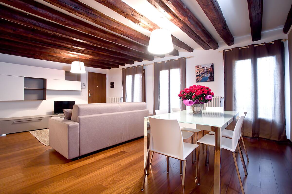 Un soggiorno moderno con divano, tavolo da pranzo, sedie e televisione.