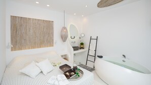 A modern bathroom with a bathtub, a vanity with a mirror, and a shower area.
