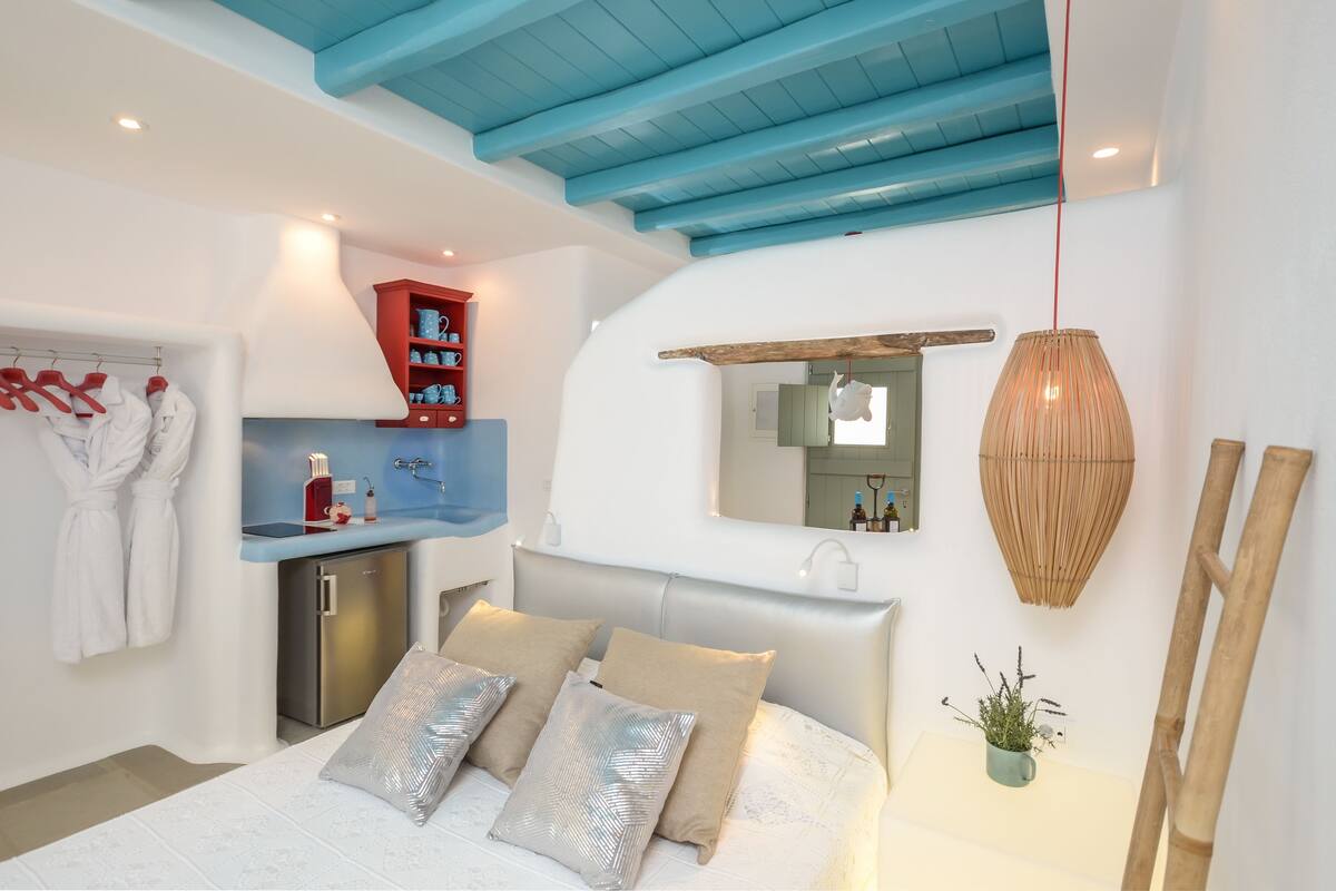 Un dormitorio moderno con cama, mesita de noche y un armario rojo.