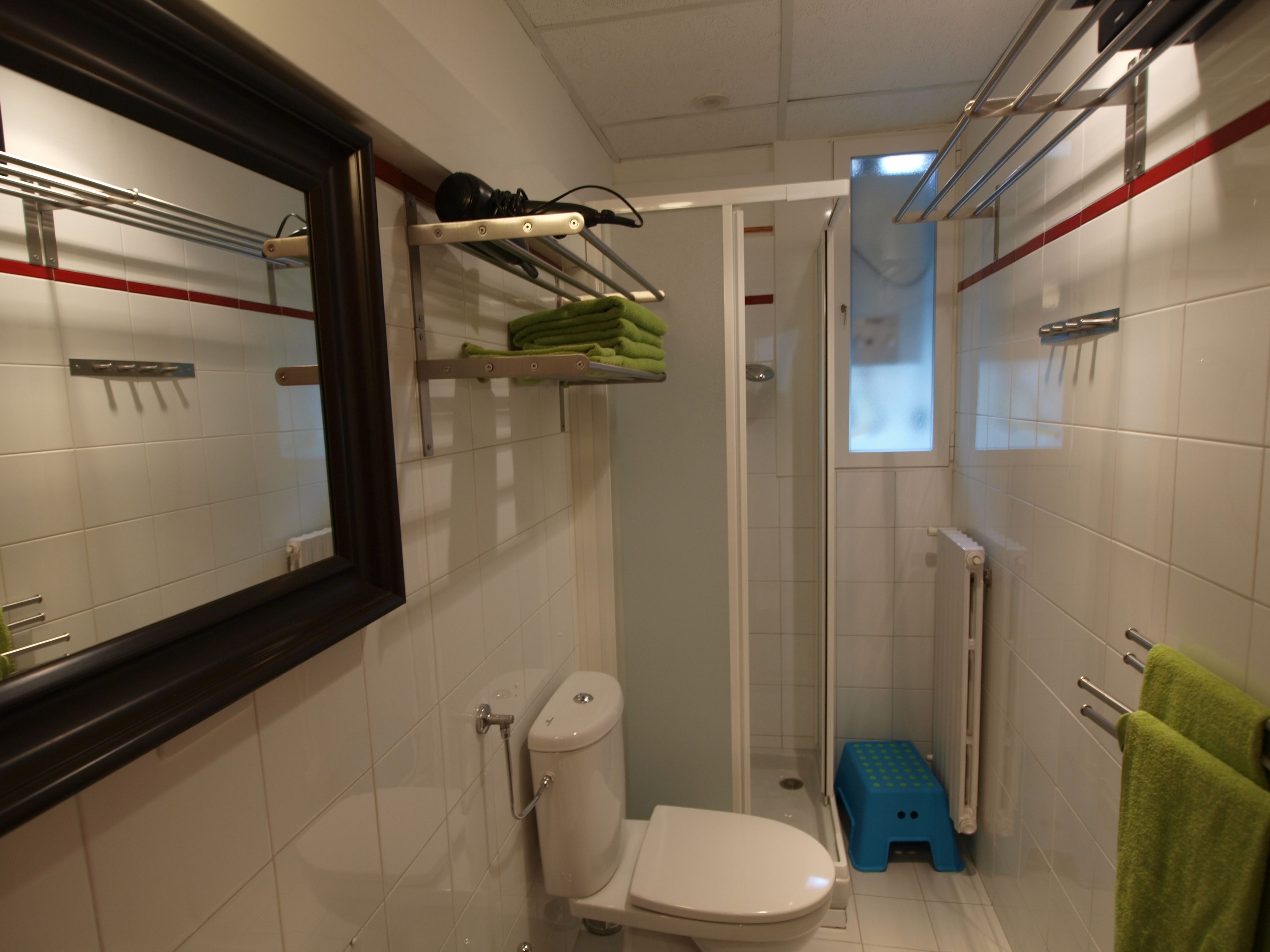 Casa de banho compacta com sanita, cabine de duche e área de lavatório.