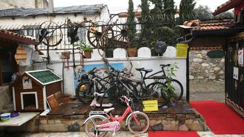 Exposição de bicicletas, com uma bicicleta vermelha em primeiro plano, cercada por diversas outras bicicletas e uma casinha de cachorro.