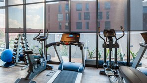 A gym with treadmills, elliptical machines, and weight machines.