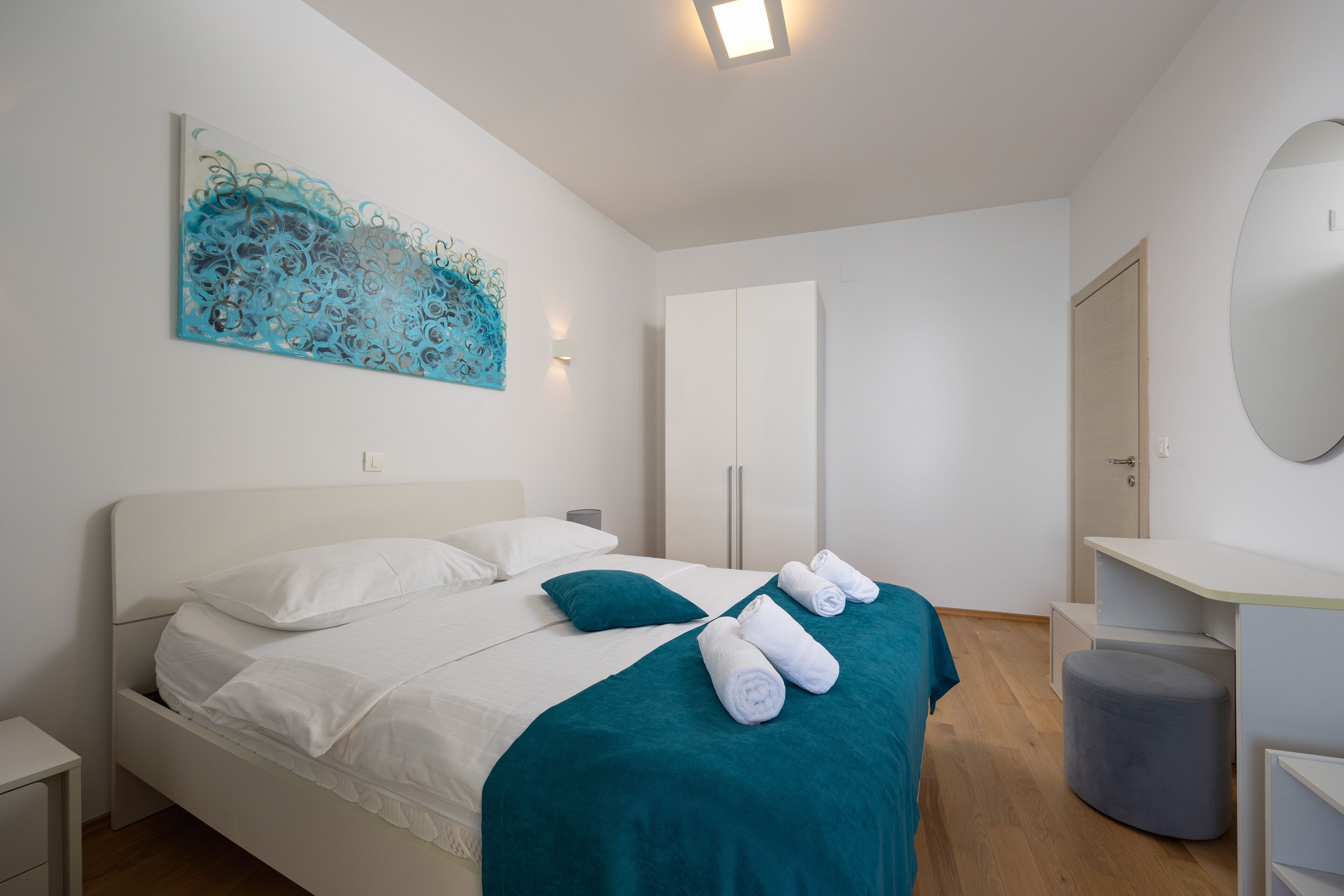 Ein modernes Hotelzimmer mit einem großen Bett, einem Schreibtisch und einem Kleiderschrank.