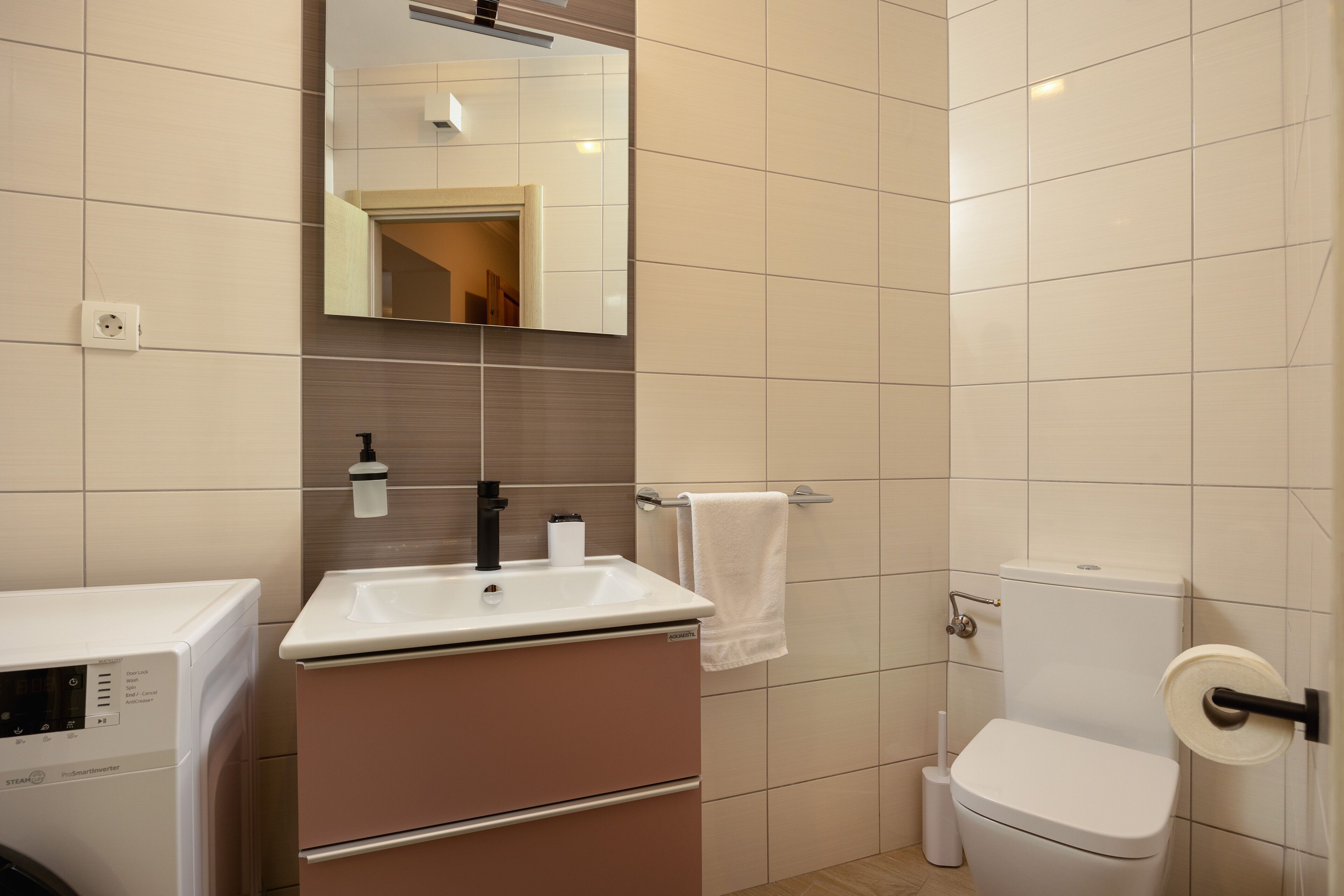 Ein modernes Badezimmer mit Waschbecken, Spiegel und Toilette.