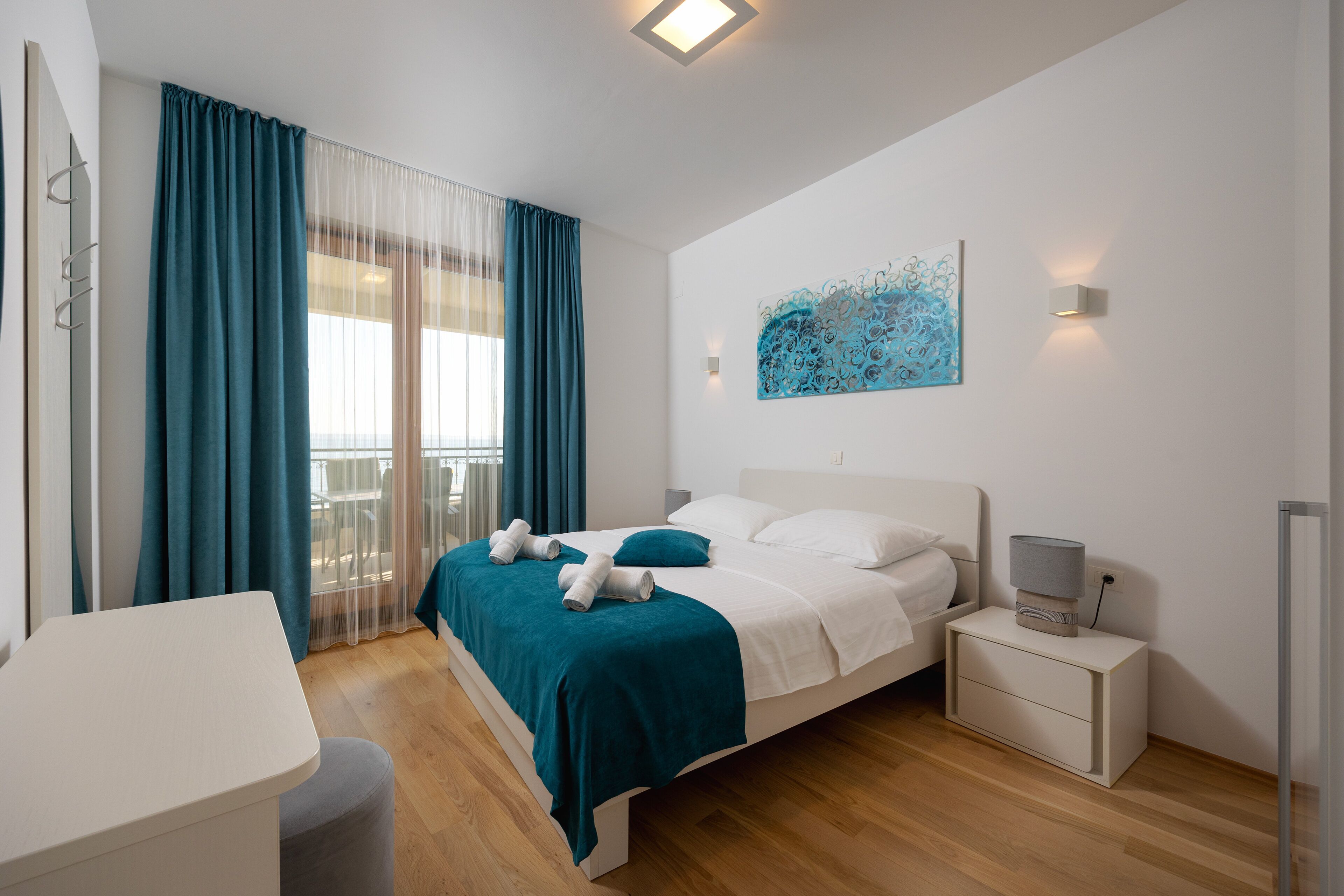 Un dormitorio moderno con cama, mesita de noche y vistas al balcón.
