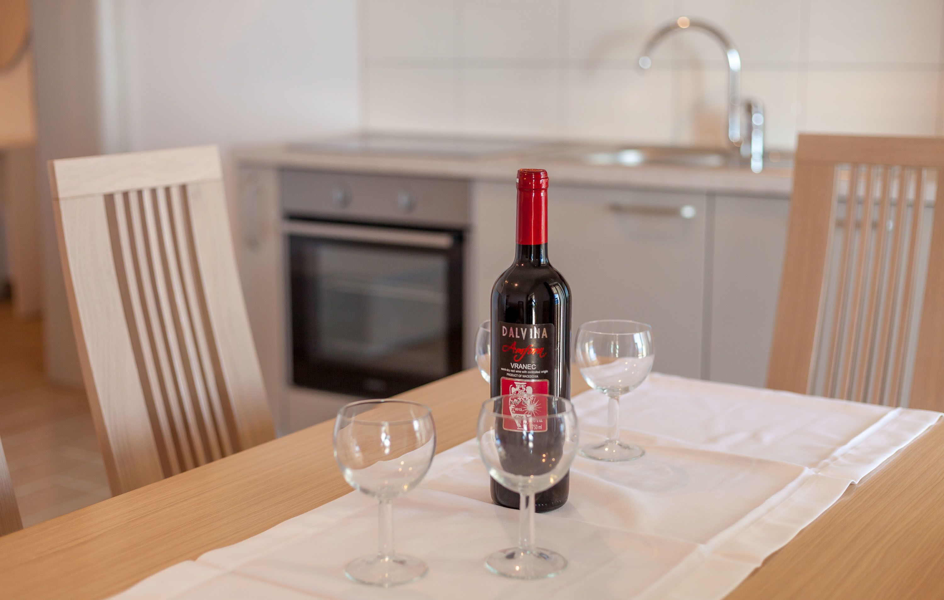 Una botella de vino sobre una mesa con dos copas.