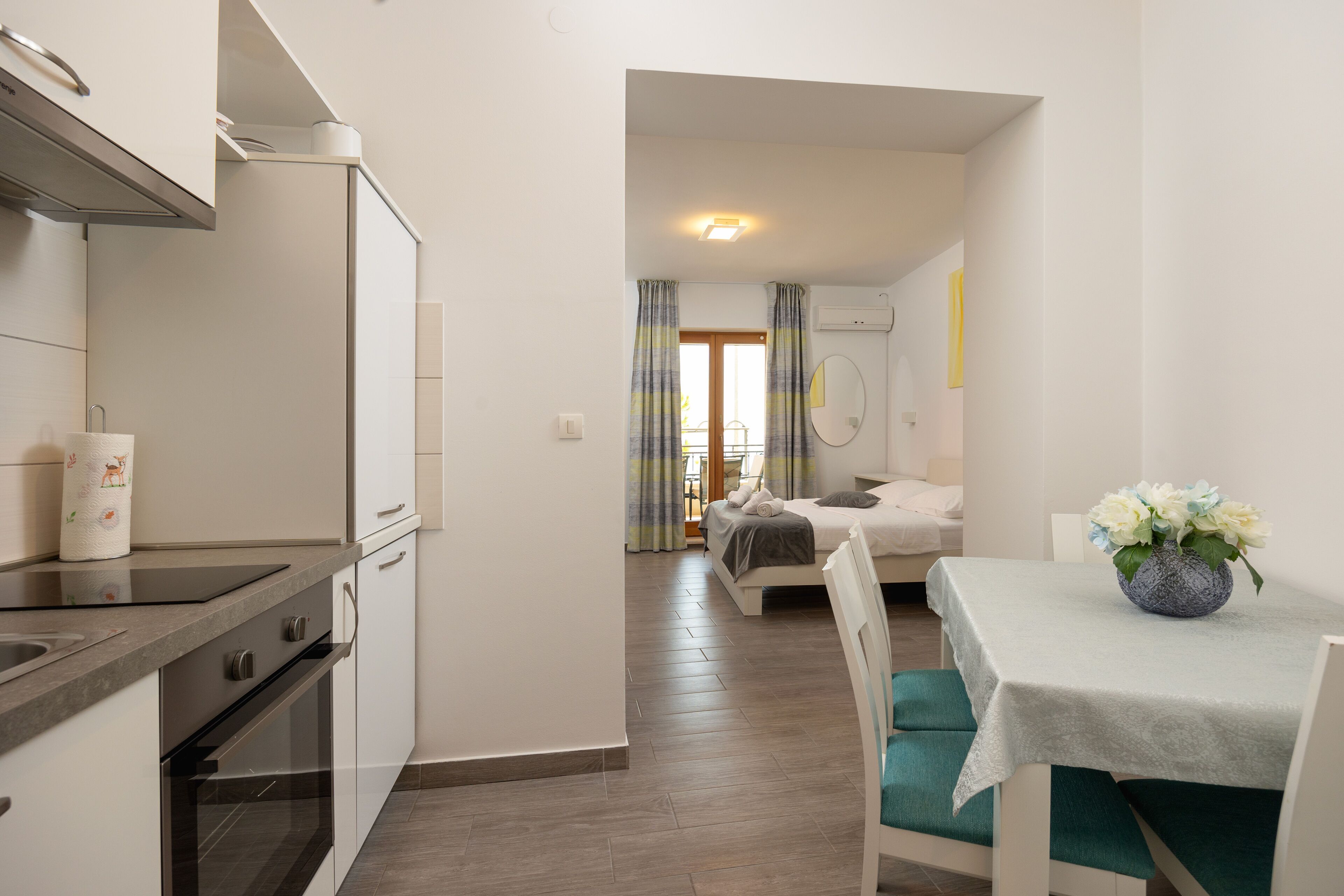 Ein kompaktes Hotelzimmer mit Küchenzeile, einem Bett mit Blick und einem Essbereich.