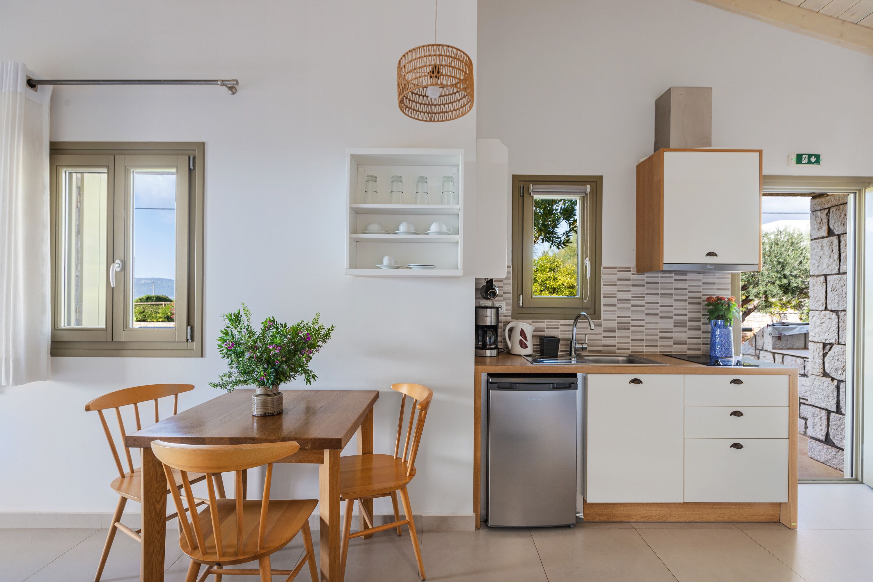 A modern kitchen with a wooden table and chairs, a dishwasher, and a built-in oven.