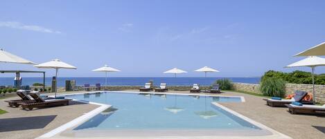 Piscine extérieure, parasols de plage, chaises longues