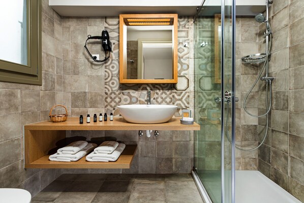 Un baño moderno con un lavamanos grande, un espejo, una ducha y un perchero para toallas.