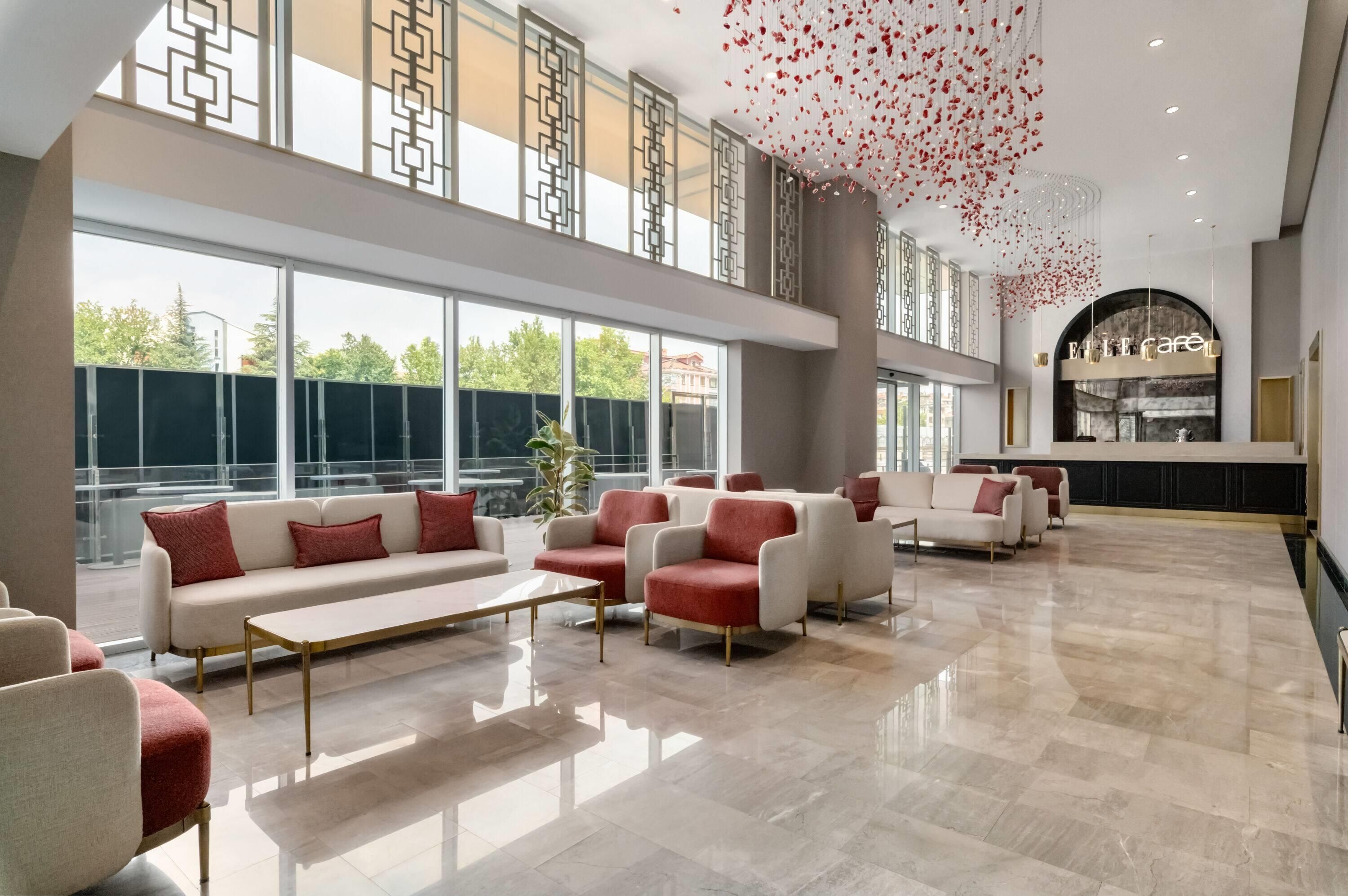 A spacious lobby with a seating area, large windows, and a decorative ceiling feature.