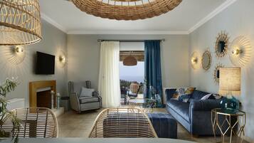 Una sala moderna con muebles de mimbre, un sofá, un televisor y una chimenea.
