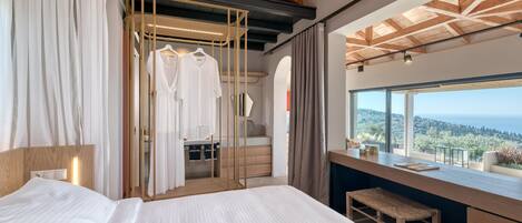 A hotel room with a bed, a vanity with a mirror, and a view of the outdoors.