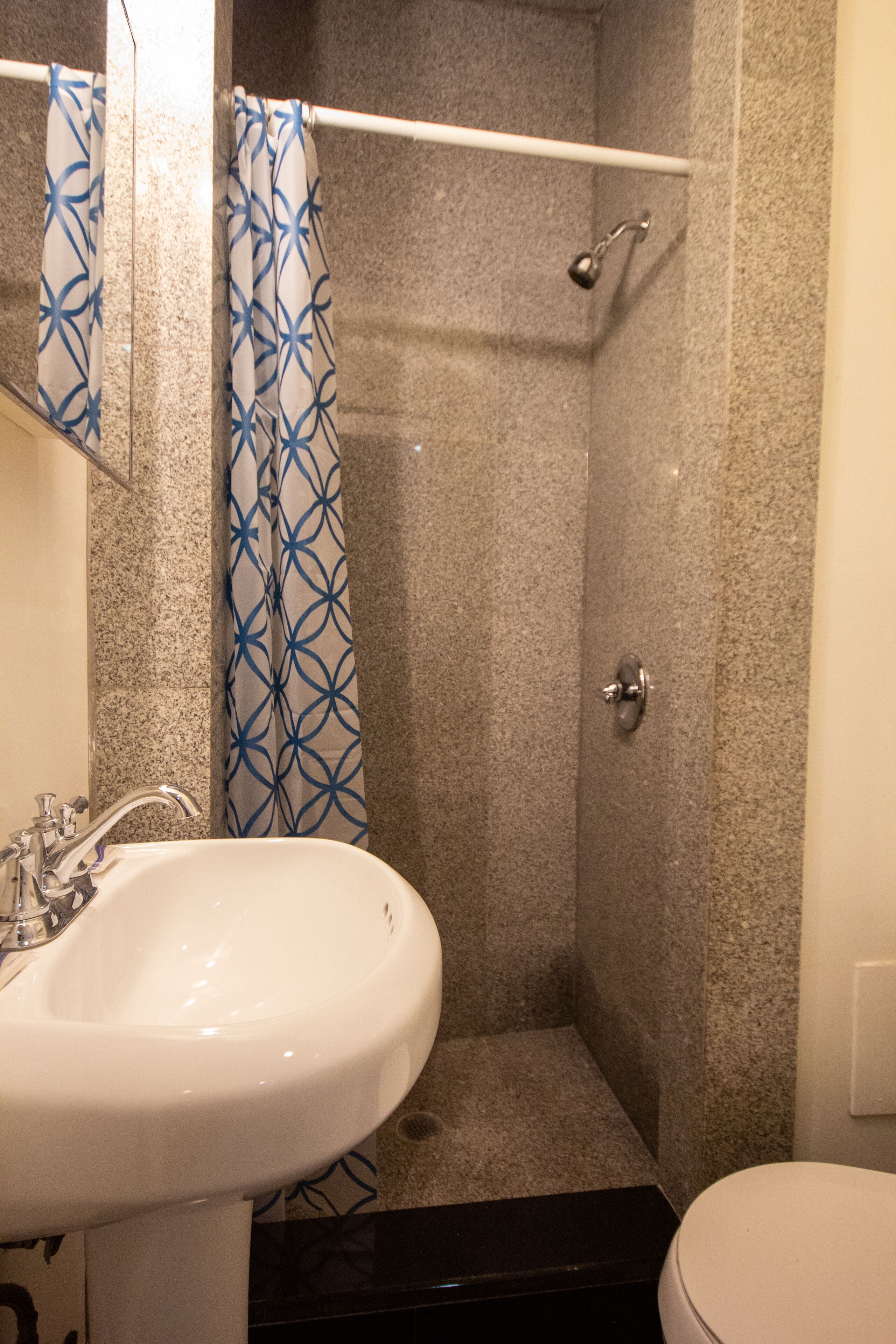 Een badkamer met een douche, wastafel en toilet.