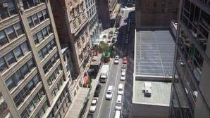 Un edificio alto con varios pisos, ventanas amplias y un estacionamiento en la parte inferior.