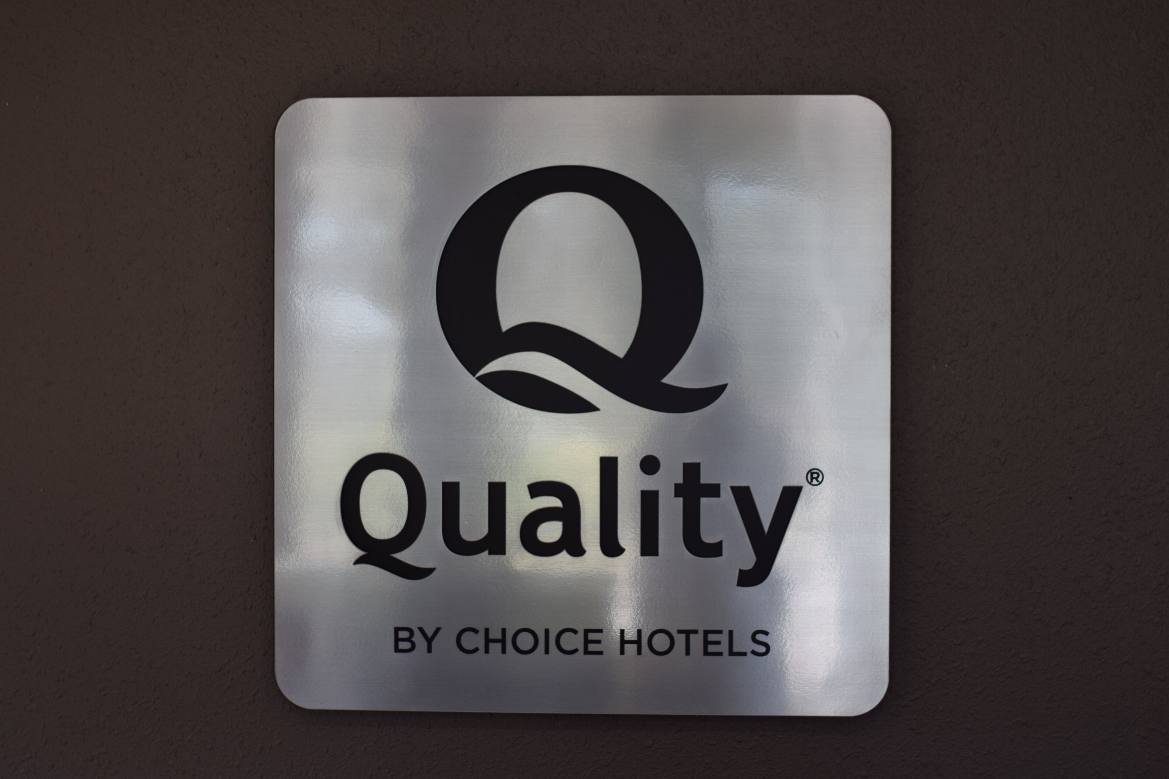 A metal sign with the logo and text "Quality by Choice Hotels".