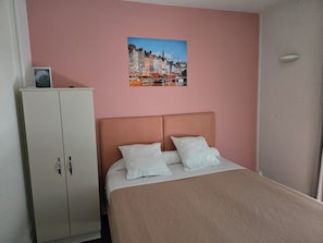 Ein Schlafzimmer mit einem Bett, einem Kleiderschrank und einem Stadtbild an der Wand.