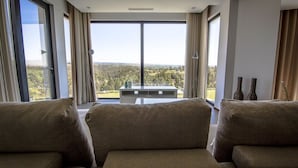 A modern living room with large windows, a view of the countryside, and a minimalist design. - Enigma - Nature & Water Hotel (Odemira)