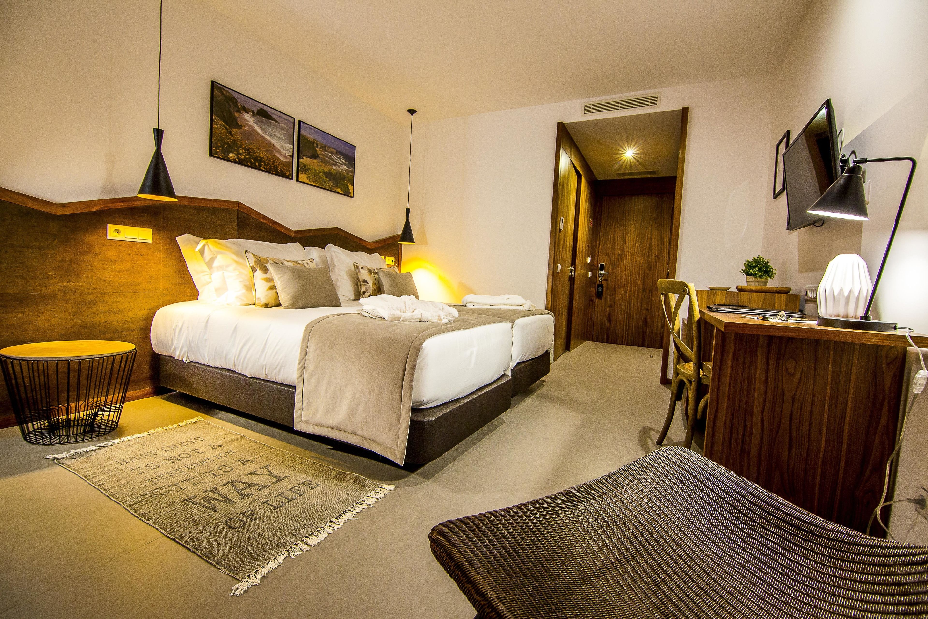 Una habitación de hotel moderna con una cama grande, un escritorio, una silla y un televisor.