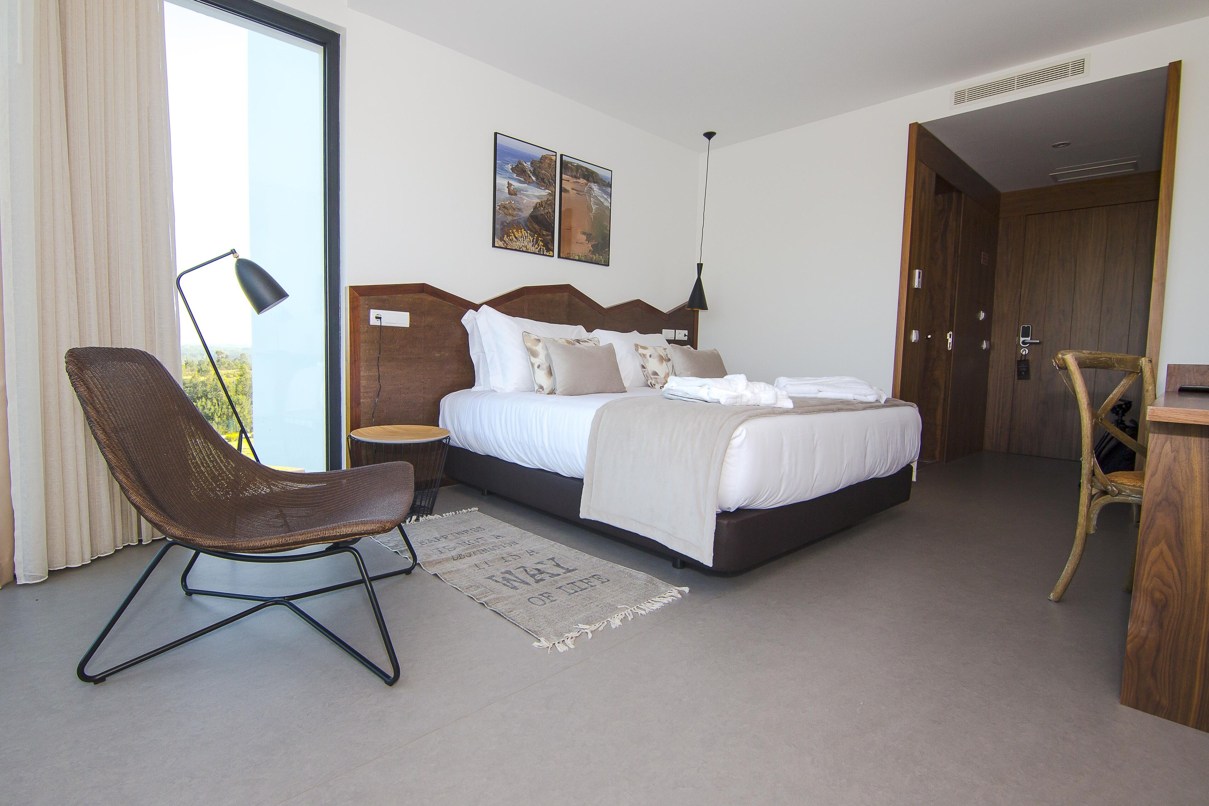 Ein modernes Schlafzimmer mit einem großen Bett, einem Schreibtisch und einem Sessel.