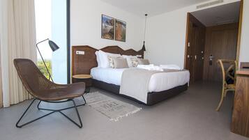 Un dormitorio moderno con una cama grande, un escritorio y una silla.