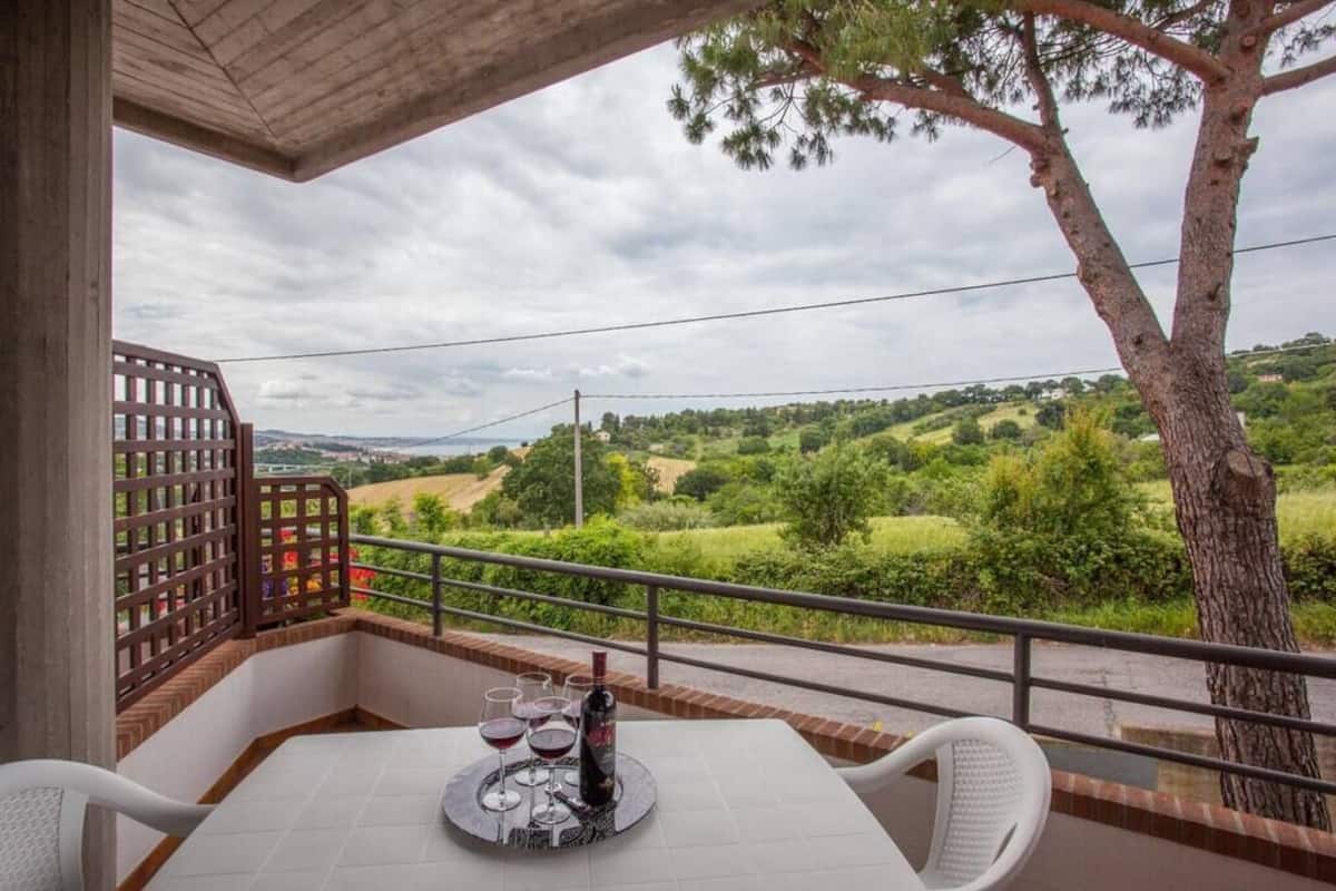 Ein Balkon mit einem Tisch für zwei Personen, mit Blick auf eine malerische Landschaft.