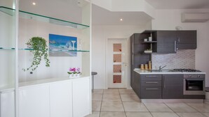 Una cocina moderna con una repisa de vidrio, un cuadro y vistas al mar.