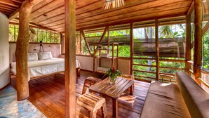 A wooden cabin with a bed, a dining table, and a sofa.