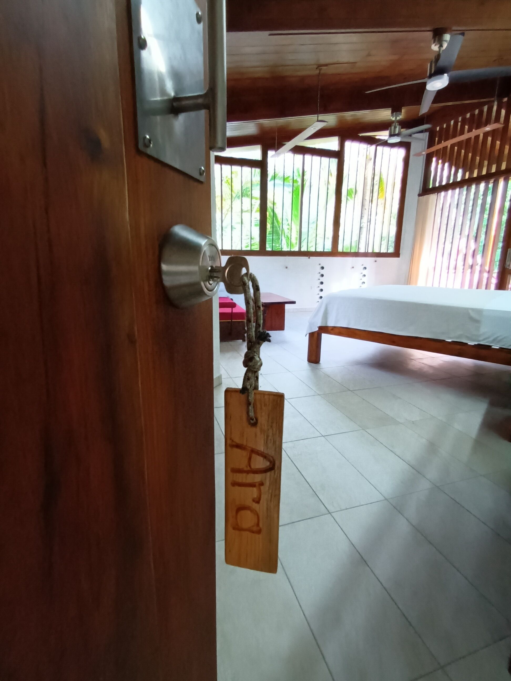 Una puerta de madera con un ojo de cerradura y un llavero con etiqueta.
