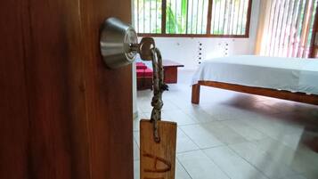 Una puerta de madera con un ojo de cerradura y un llavero con etiqueta.