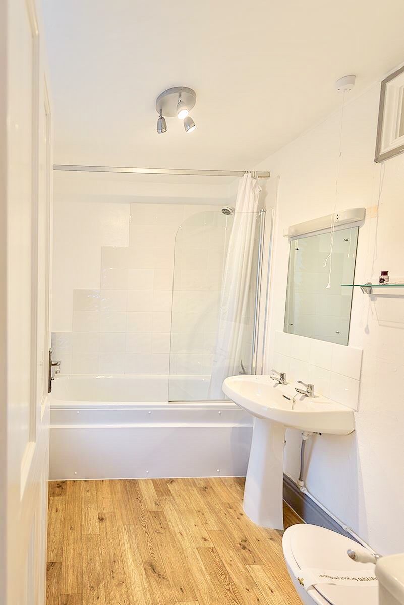 A bathroom with a bathtub, a shower, and a sink.