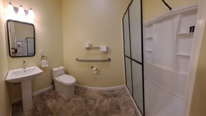 Une salle de bain équipée d’un lavabo, de toilettes et d’une douche à parois en verre.