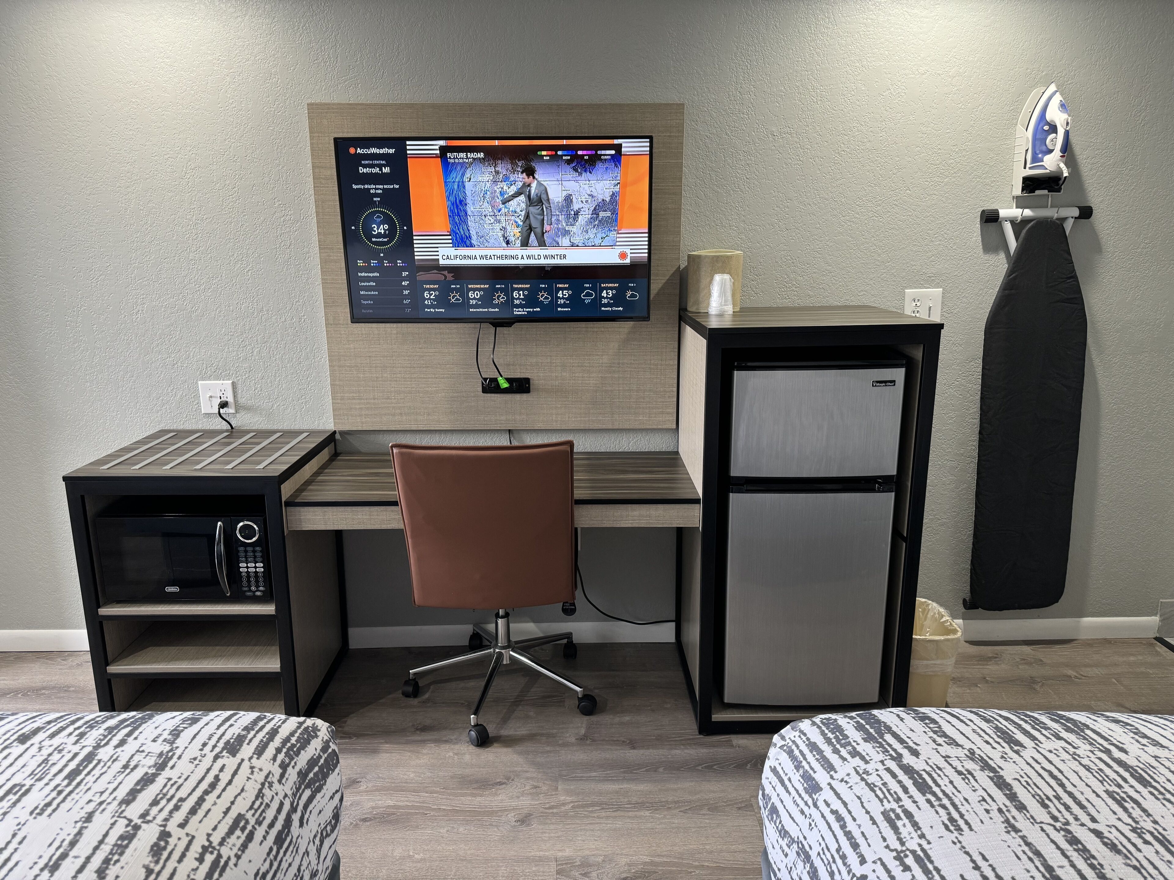 A modern office space with a desk, chair, and a small refrigerator.