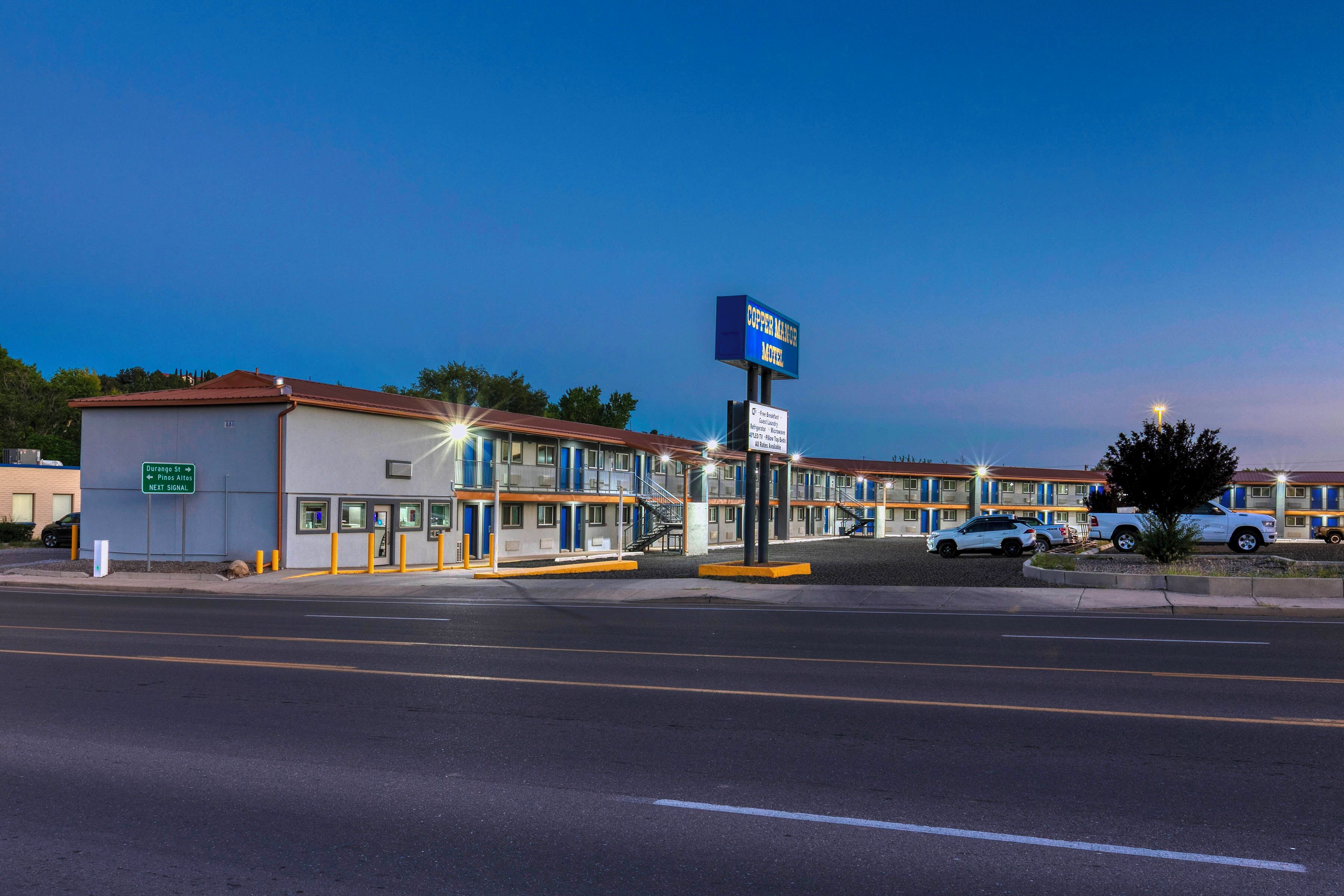 A motel with a signboard, a parking lot, and a street view.