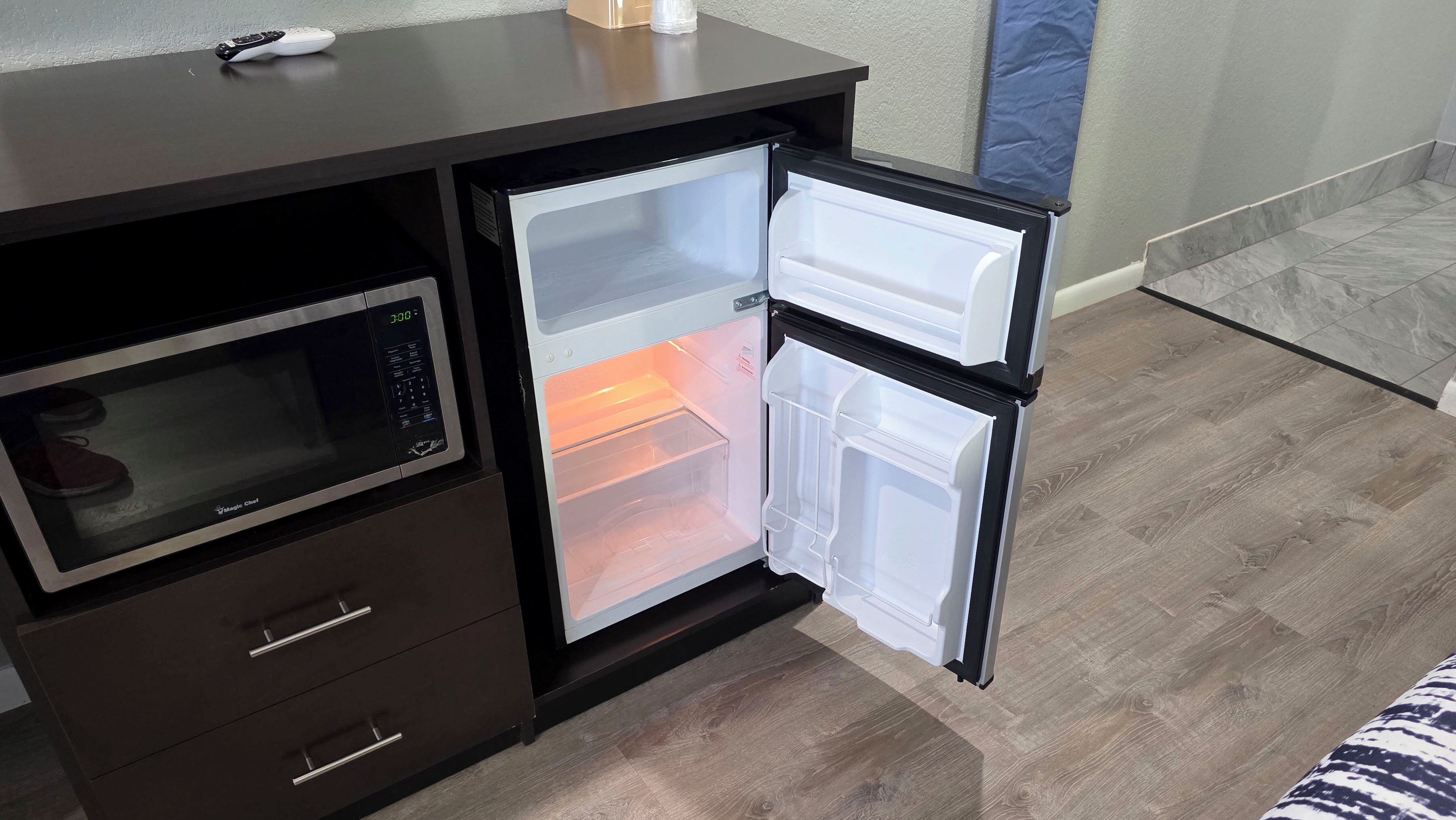 A compact kitchenette with a microwave, refrigerator, and a small oven.