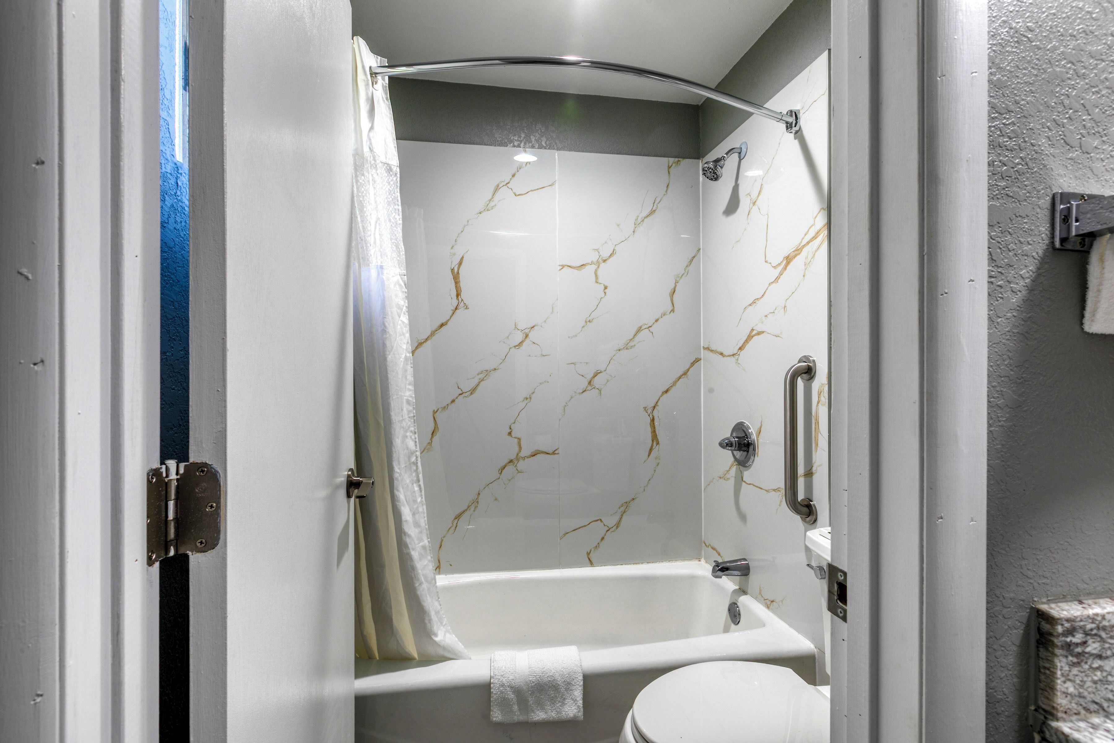 A bathroom with a shower, toilet, and bathtub.