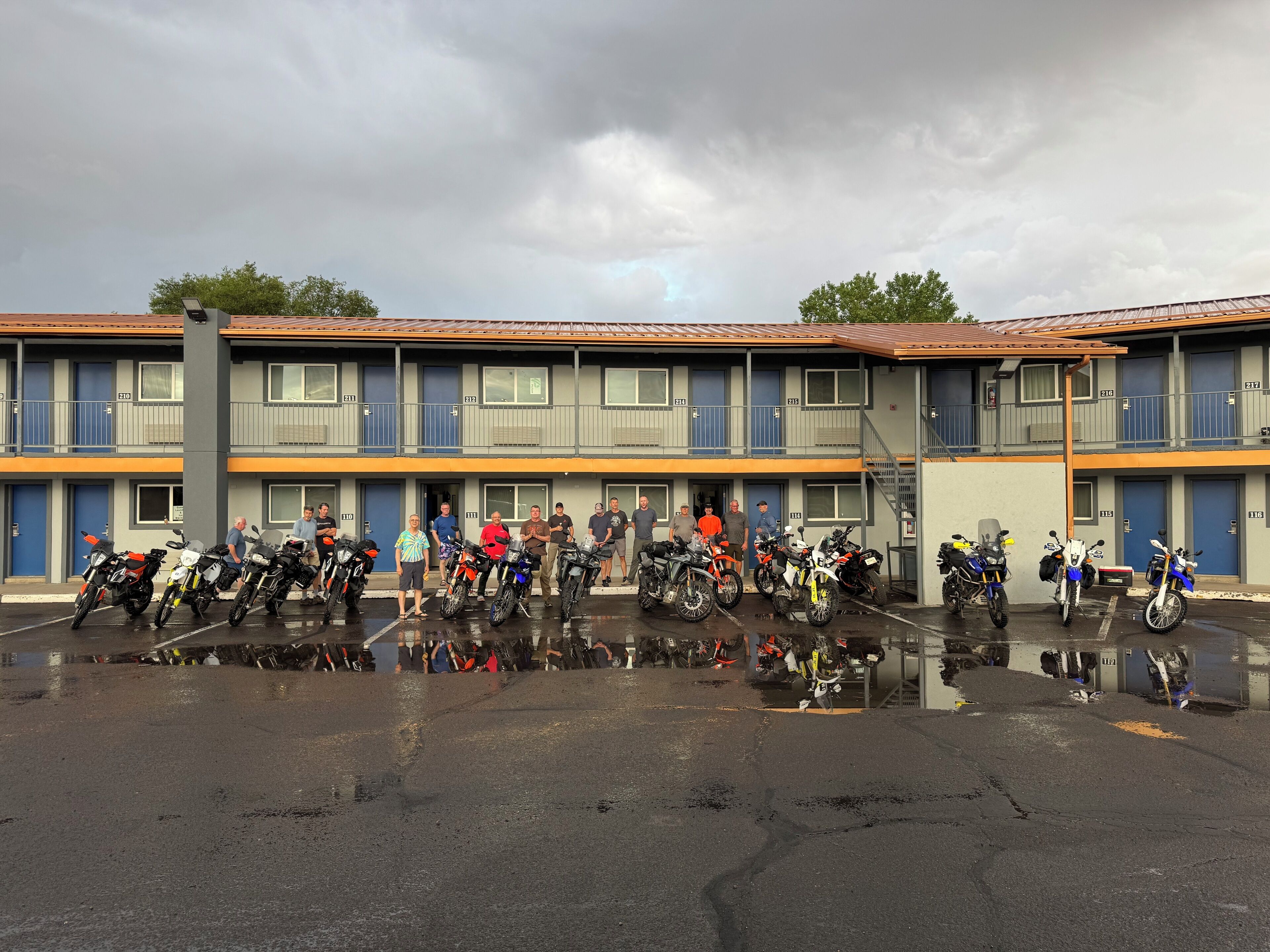 A multi-story motel with a parking lot filled with motorcycles.