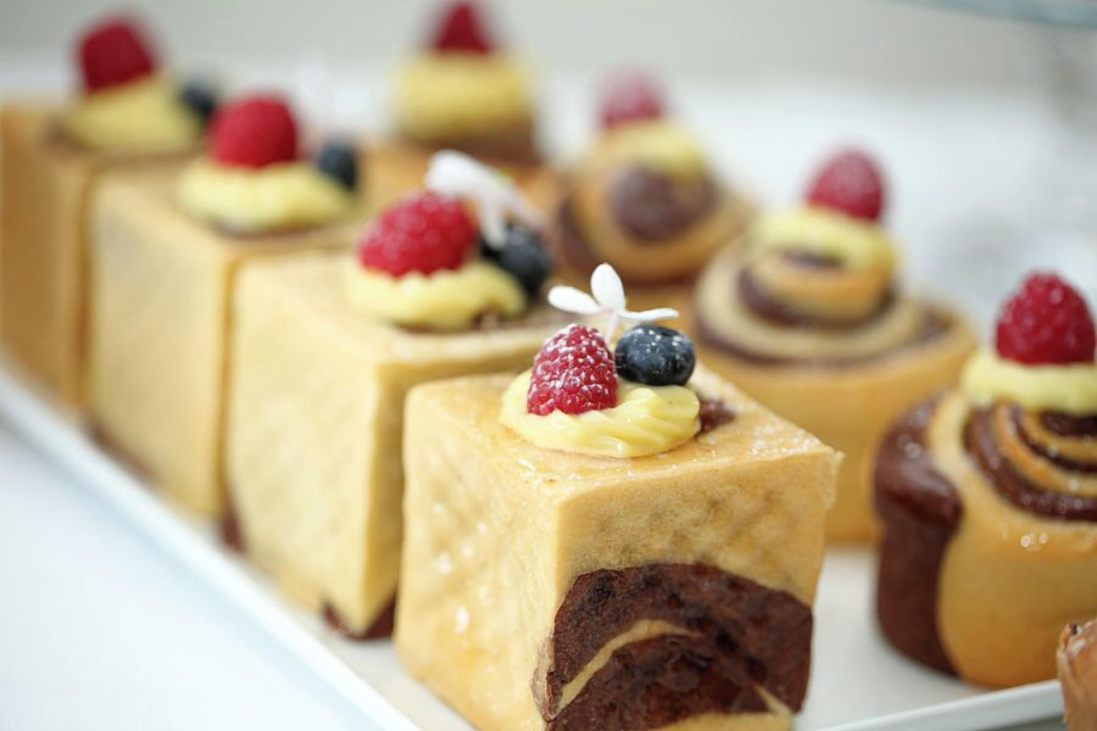 A variety of desserts, including cakes and pastries, arranged on a white plate.