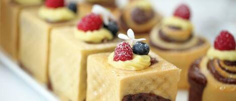 A variety of desserts, including cakes and pastries, arranged on a white plate.