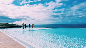 Piscine couverte, piscine extérieure, parasols de plage, chaises longues