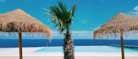 Piscine couverte, piscine extérieure, parasols de plage, chaises longues
