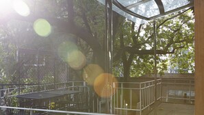 An outdoor patio area with metal railings, a table, and chairs. - Jiwoljang Guest House (Seoul)