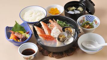 Diversos platos japoneses, como arroz, mariscos y sopa, dispuestos sobre una mesa.
